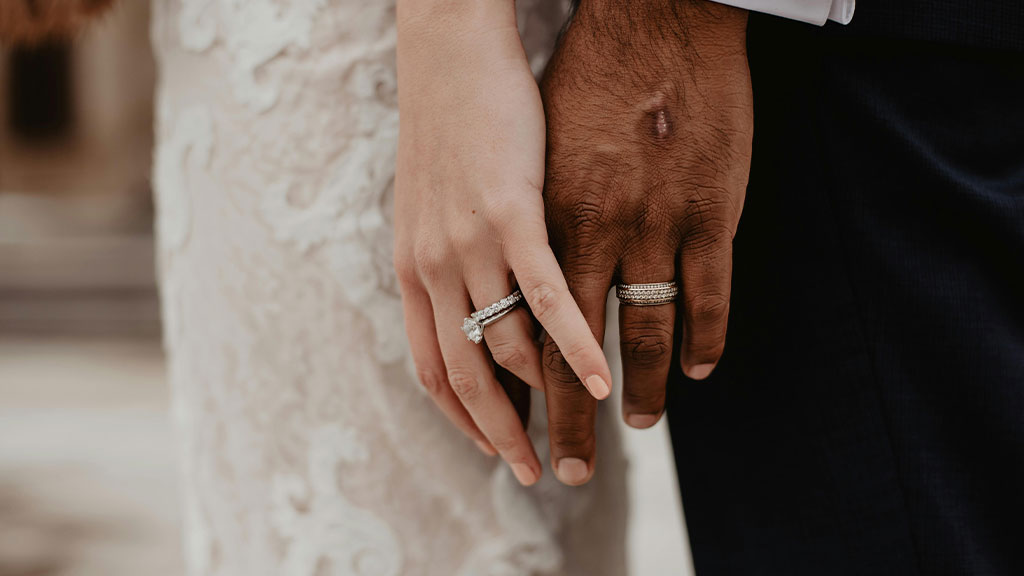 hands of a married couple caressing each other, the black man and the white woman