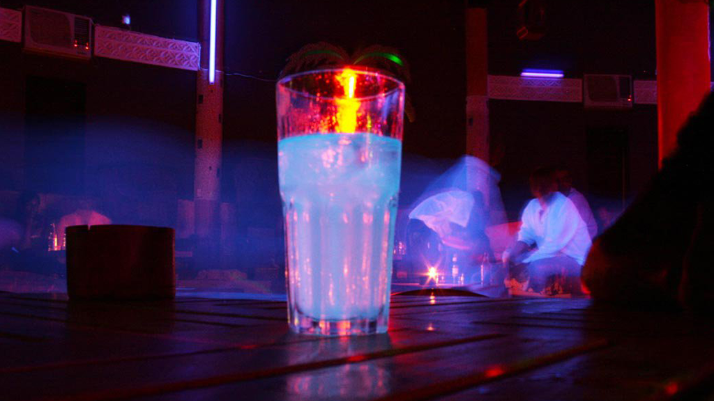 glass with drink on the counter of a bar